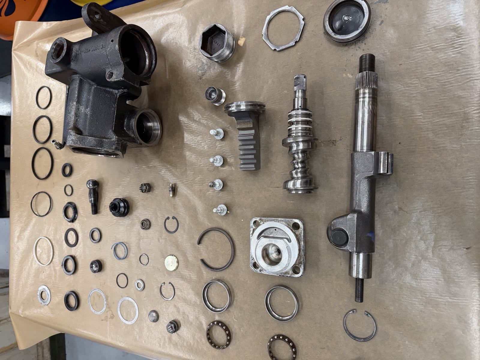 Every internal component of the 1988 Adwest steering box laid out: housing, shafts, piston, valve, bearings, seals and clips