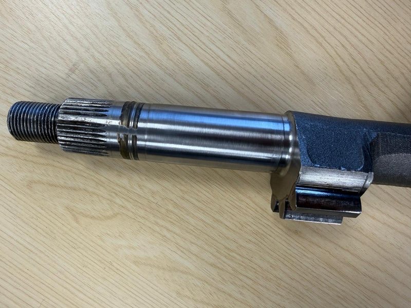 Sector shaft removed from the steering box, showing the shaft end turned down below size with a substance attached